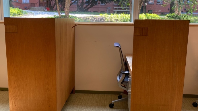 two wooden study carrels near a window