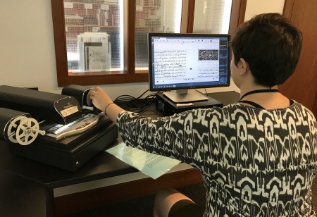 A library staff member uses a microform reader in the Fine Arts Library. 