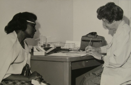 Black woman talking with white medical professional in an office