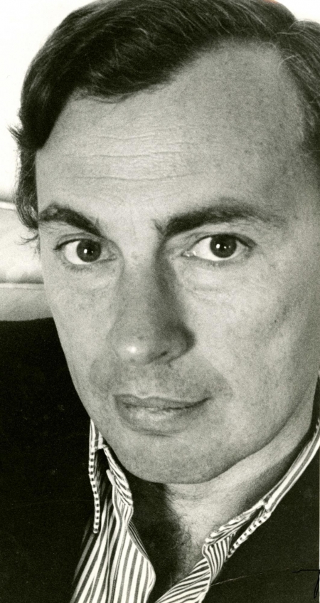 Gore Vidal, wearing a collared shirt, looks expressionless at the camera