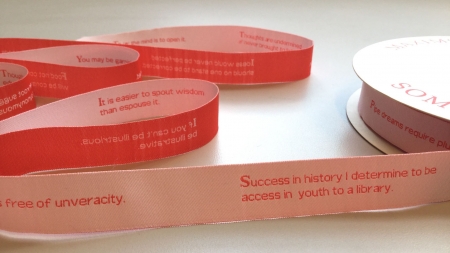 A long piece of ribbon tape with text written on it