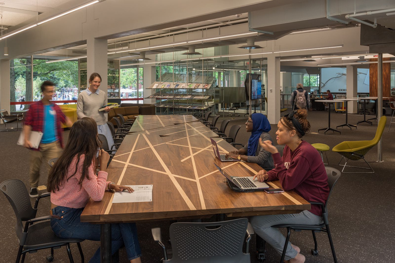 students gather around a table in cabot library