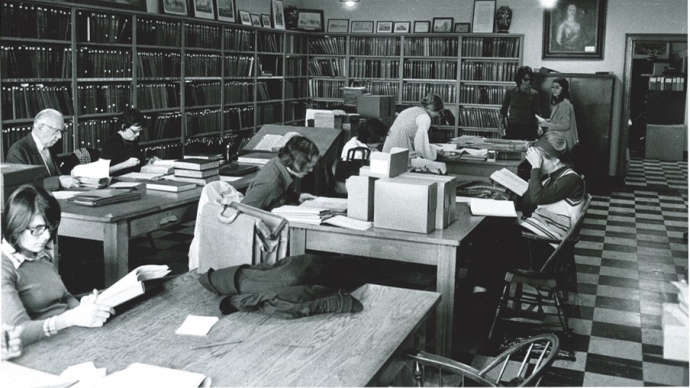 Researchers working at tables in a library reading room.