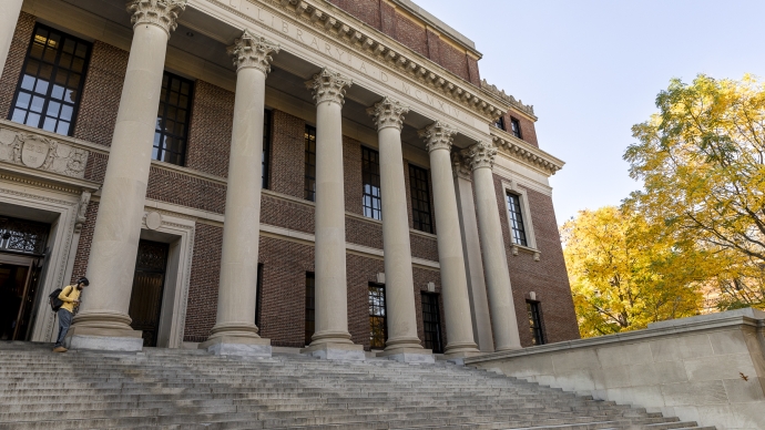 View of Widener Library steps with tree turning color in the background.