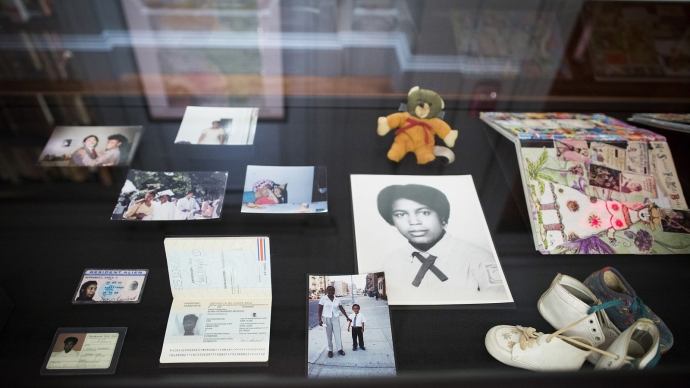 An exhibit at Houghton Library with photos and miscellaneous documents laid out on a table