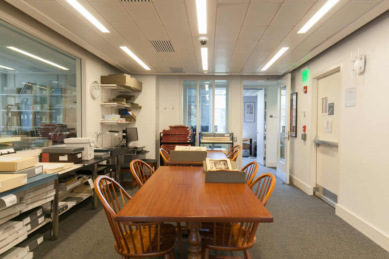 A large, wooden shared desk space with chairs