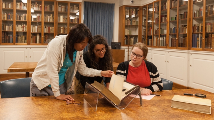 People inspect a rare book