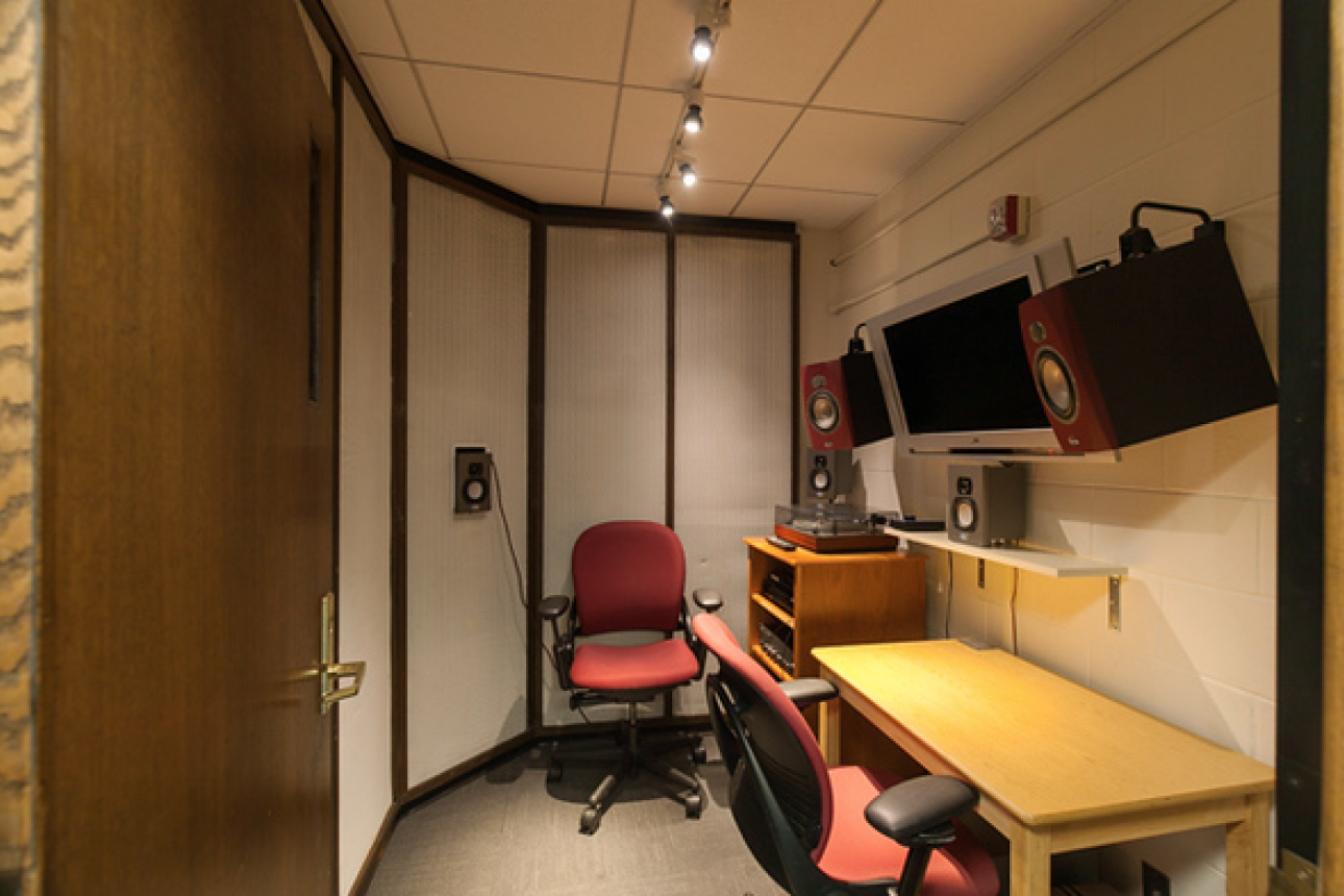 A room for listening to materials at the Loeb Library features two chairs, a desk, and various equipment