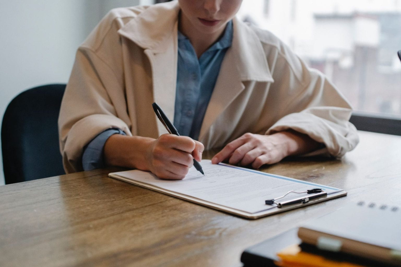 A woman writing something down on a piece of a paper