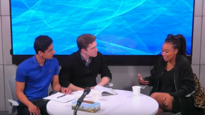 Three people sit around a table in the Media Studios during a recording session for the 2 Million Minutes podcast. 