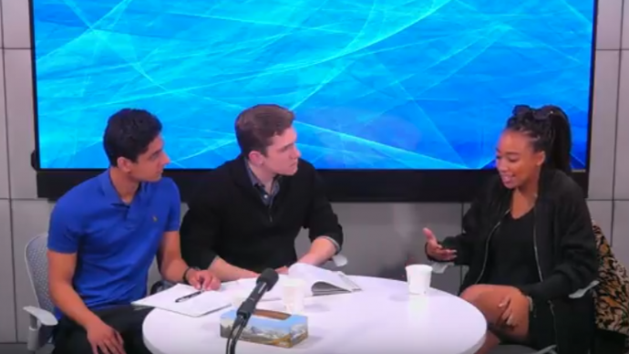Three people sit around a table in the Media Studios during a recording session for the 2 Million Minutes podcast.