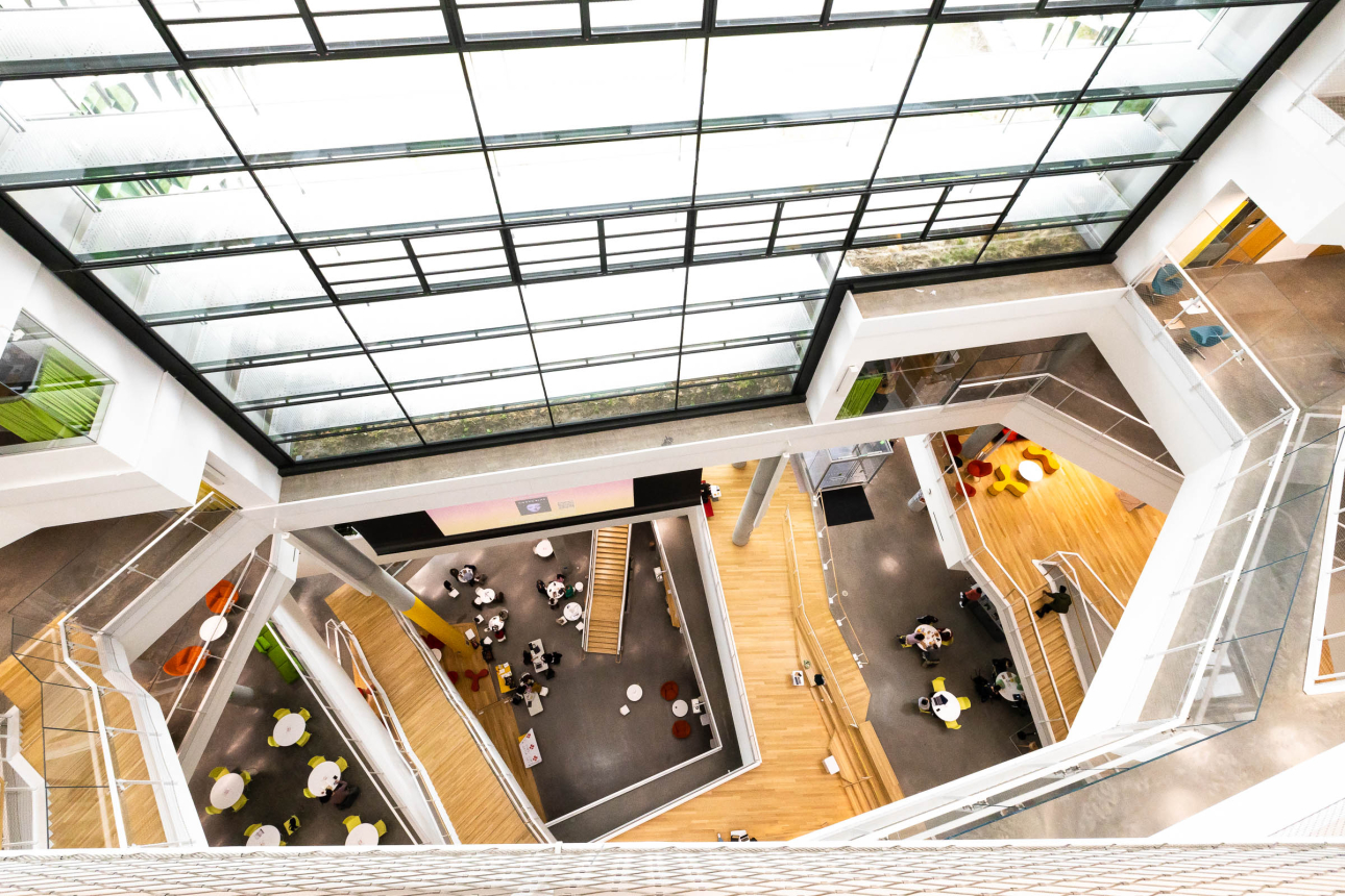 A view inside the Science and Engineering Complex, looking down several floors along a large wall of windows.