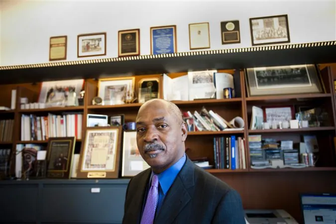 Head and shoulder view of Charles Ogletree standing in front of built-in bookshelves.