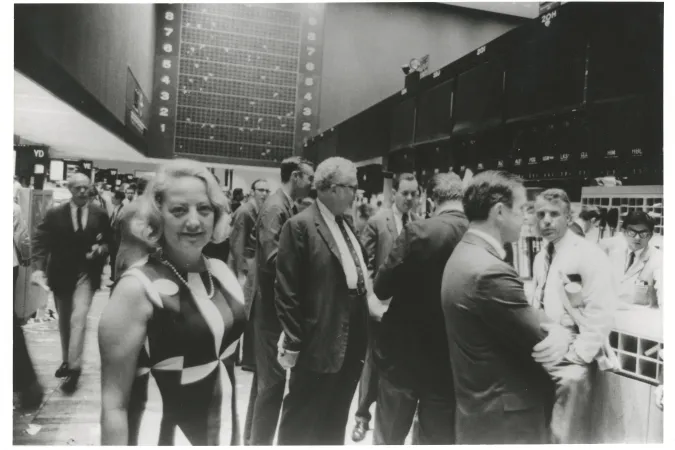 Muriel Siebert on New York Stock Exchange floor surrounded by men