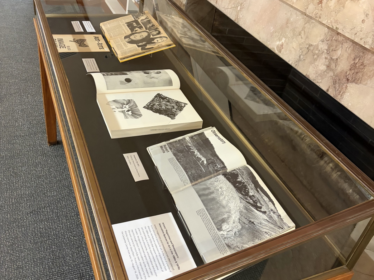 Vitrine with multiple artists’ magazines visible, close up of Avalance open to images of an earth art project in process 