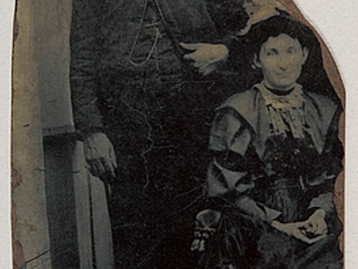 Tintype photo of a man and a woman with the third figure in the back being cut out