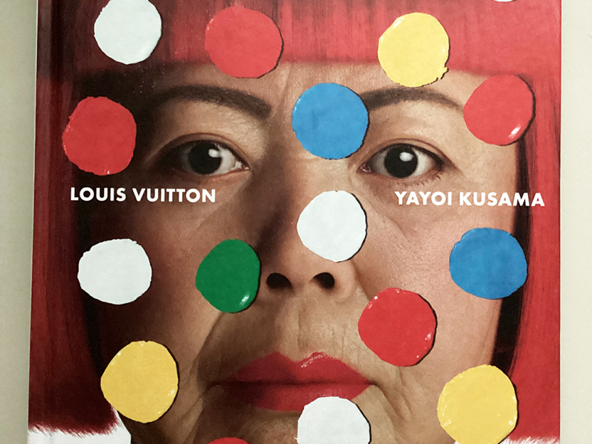Book cover featuring a photo of Kusama with red hair wig with colorful dots over her face