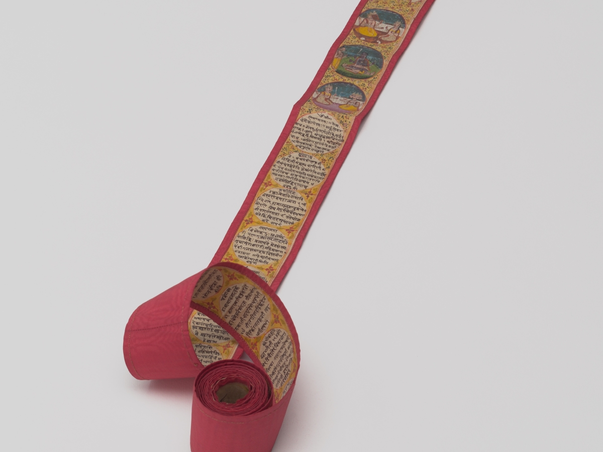 An unfurled miniature scroll with red backing, with script and portraits of Hindu deities.