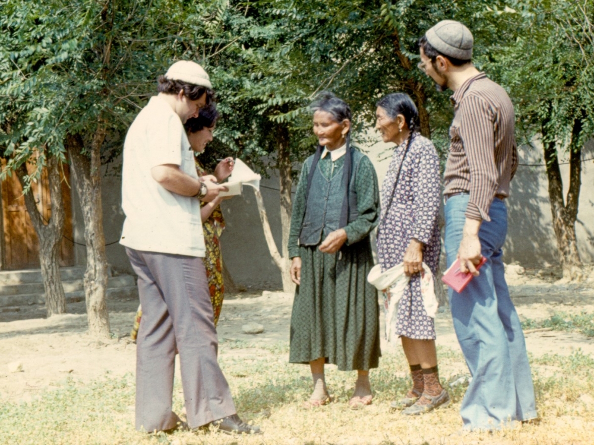 Siberian-born ethnomusicologist Eduard Alekseyev (far right), wearing blue trousers, looks on as two women sing and two unidentified colleagues record their performance.