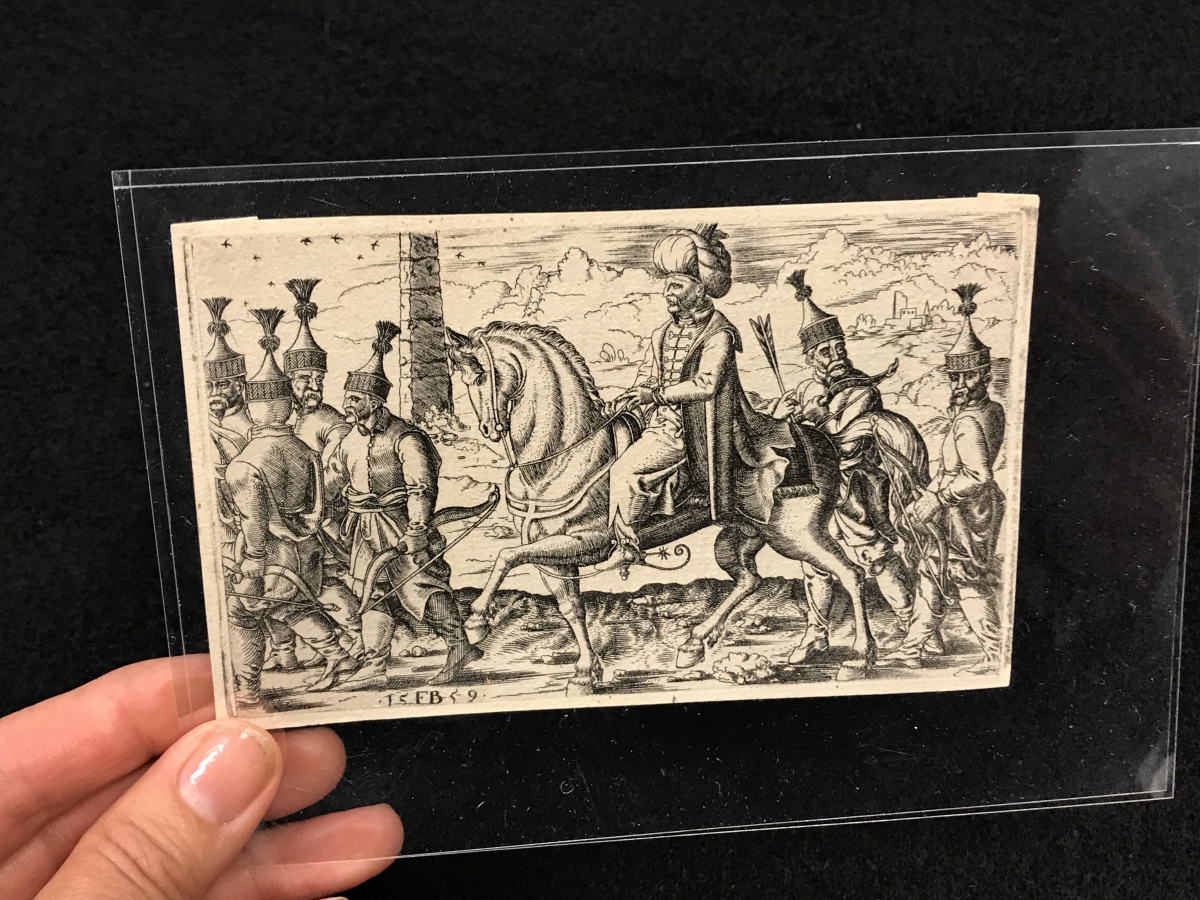 hand holding a drawing of a man on a horse