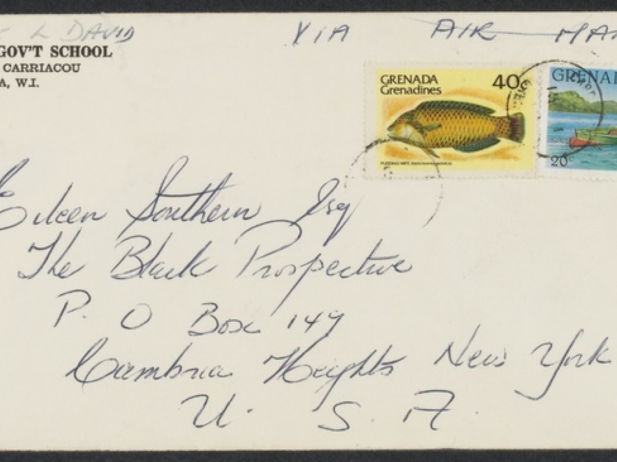 A hand-addressed envelope sent via air mail from Grenada, with two colorful stamps, one of a fish and one of a group of people in a boat.