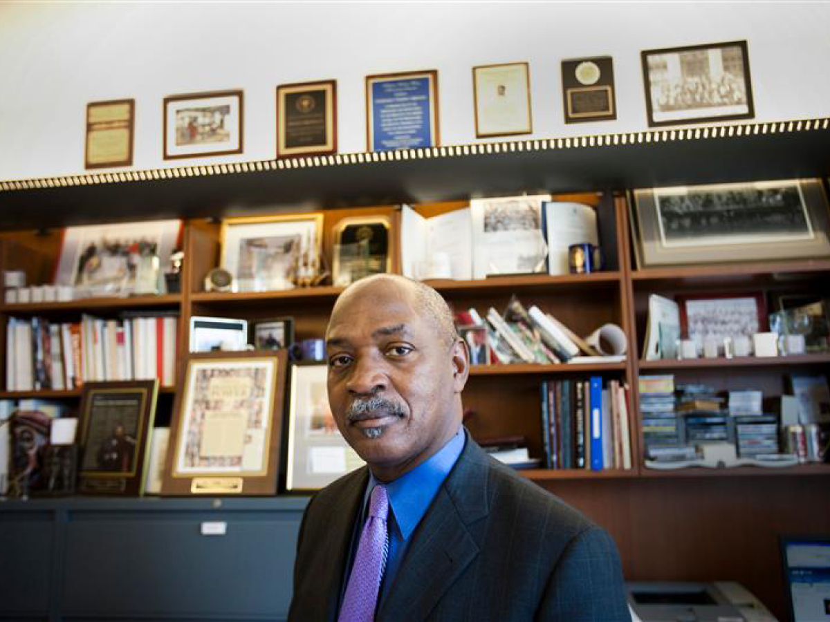 Head and shoulder view of Charles Ogletree standing in front of built-in bookshelves.