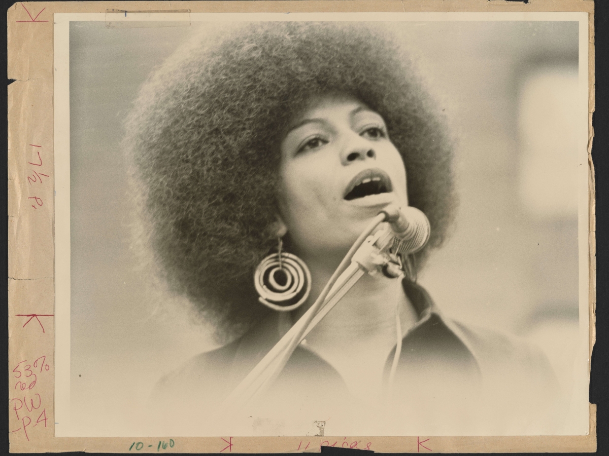 Photograph of Angela Y. Davis speaking into a microphone. 