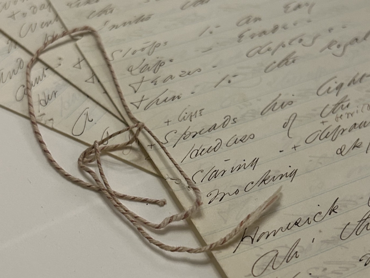 Poetry written on lined paper that is bound together with twine.