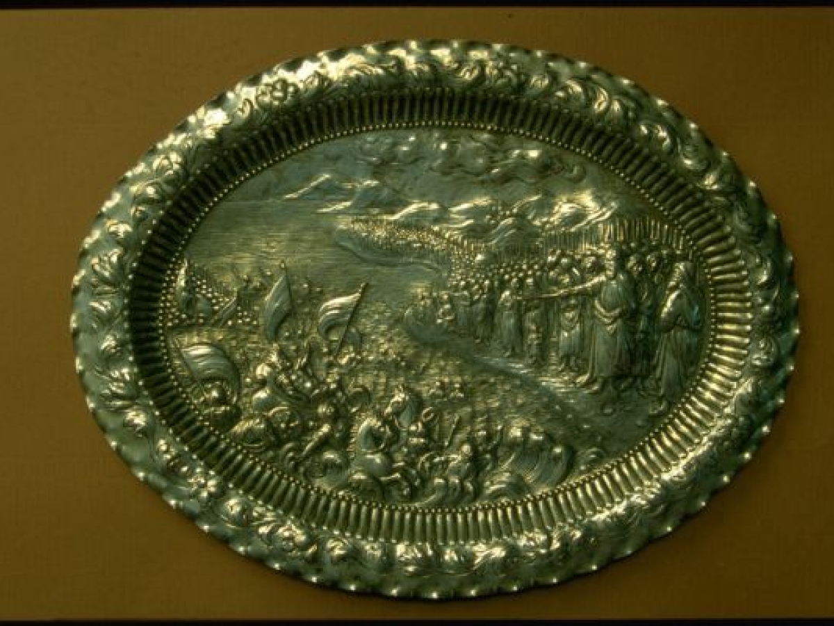 Metal seder plate depicting the parting of the Red Sea. 