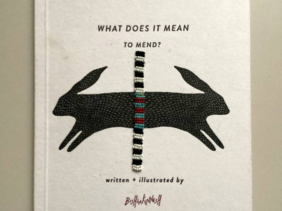 Photo of a book that includes an illustration of black rabbits and a beaded band