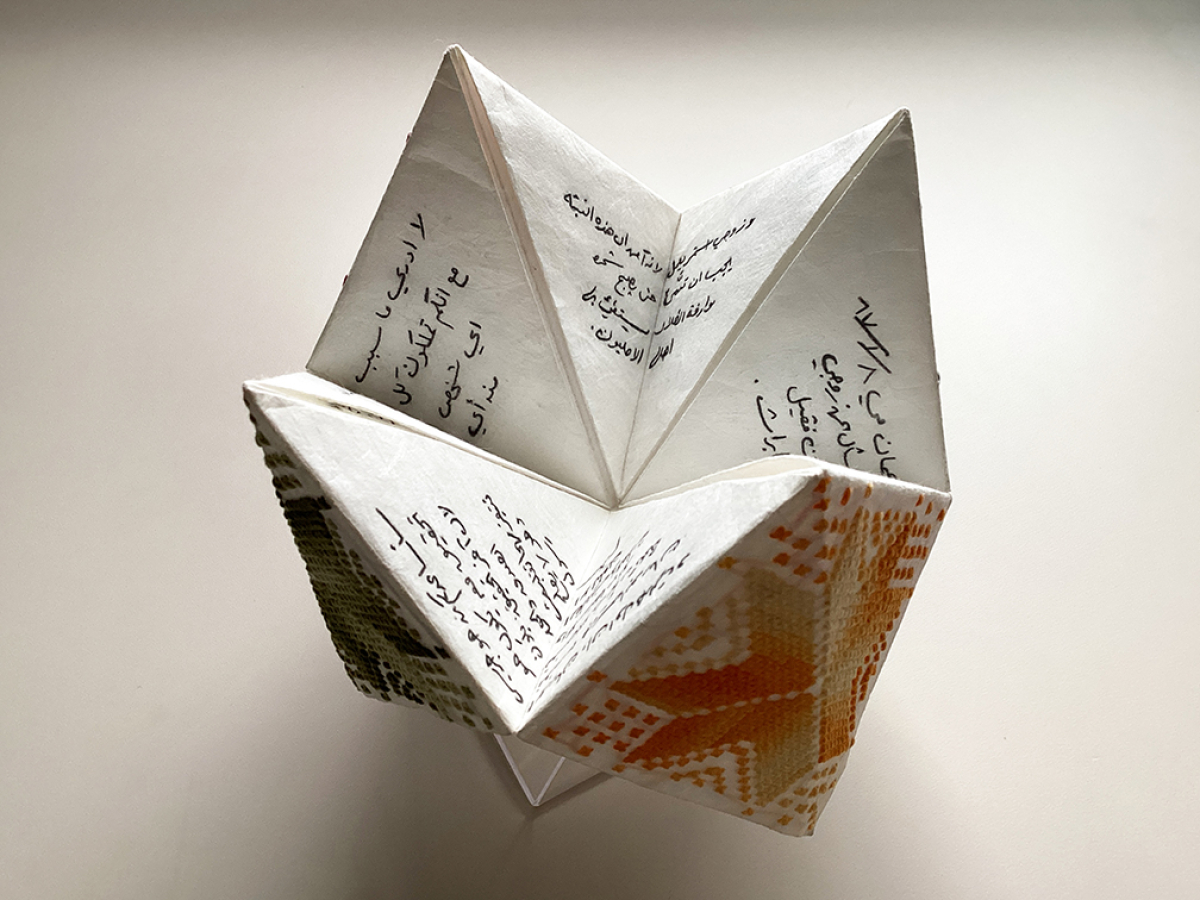 Photo of artists' book with woven design and Arabic texts