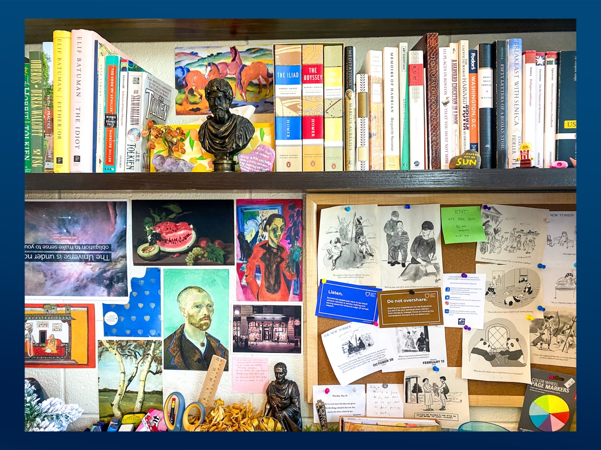 Photo of a shelf with books from and about ancient Greece, with a small bronze bust, a bulletin board covered with clippings of art and cartoons, and other small objects 