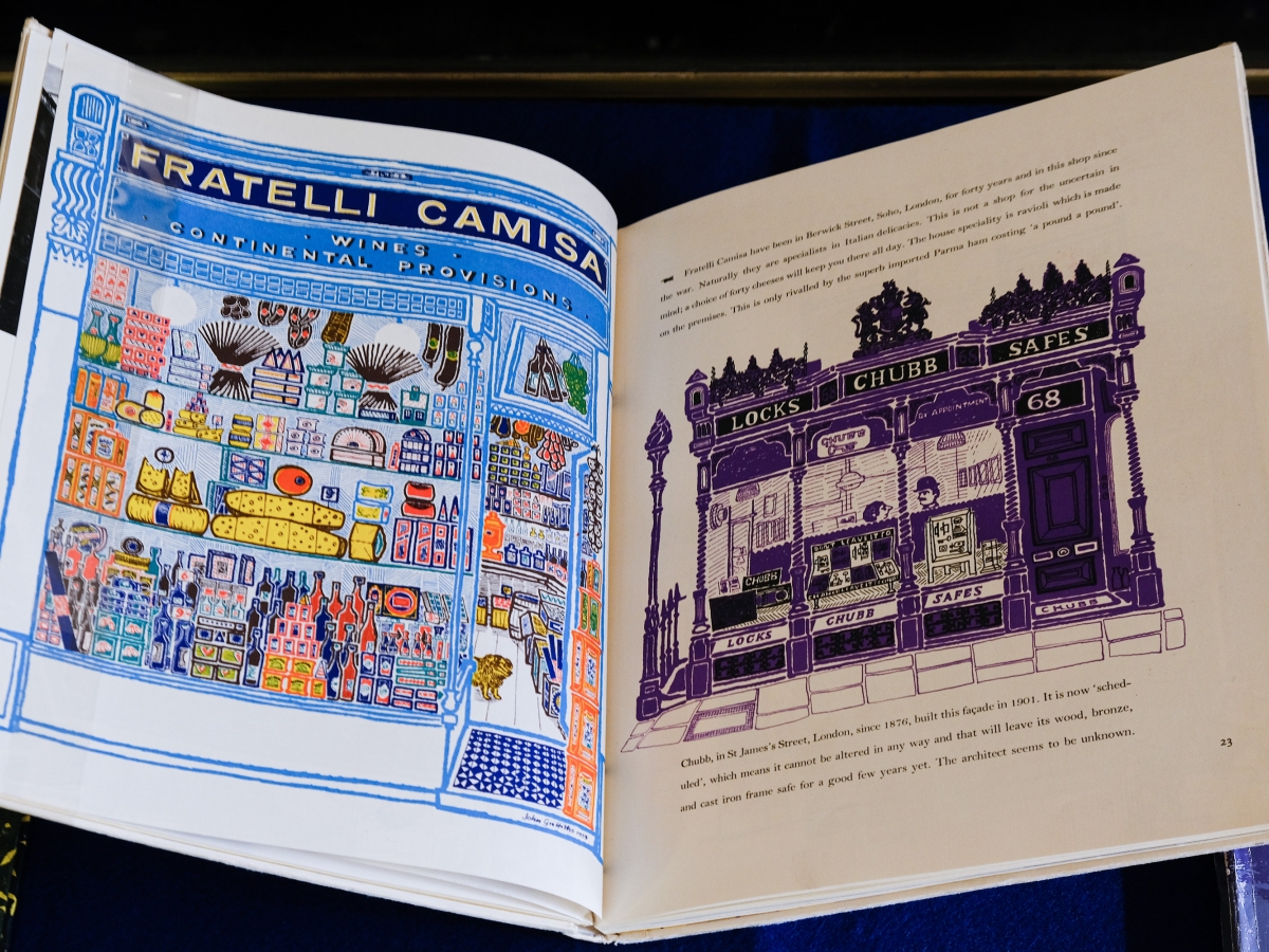 Page spread from MOTIF magazine. Left page shows a colorful illustration of the storefront of cheese and wine shop. Right page shows an illustration of a locksmith storefront.