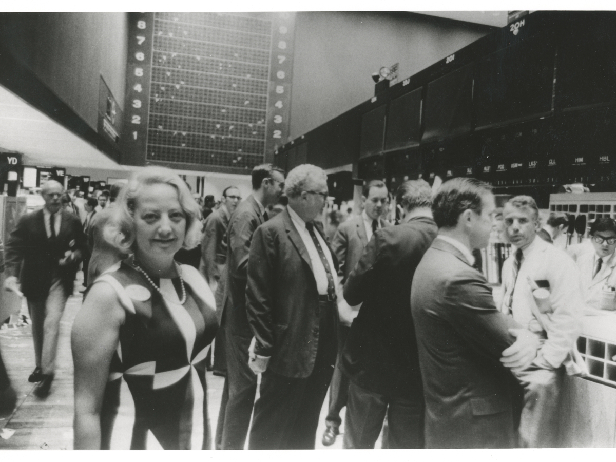 Muriel Siebert on New York Stock Exchange floor surrounded by men
