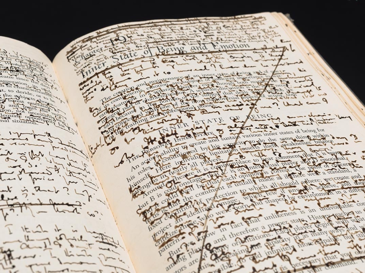 An open book with text hand-written between the printed lines.