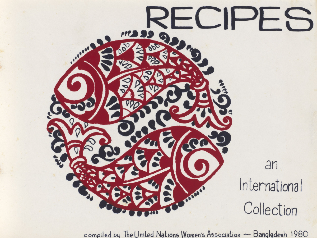 Title page for Recipes, an International Collection. Paper is white and there is a black and red illustration of two decoratively drawn fish forming a large circle in the middle of the page. The text compiled by The United Nations Women's Association, Bangladesh 1980 is along the bottom edge.