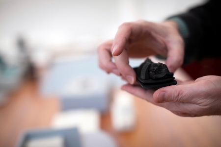Conservator's hands holding a burned book fragment