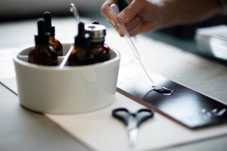 Hands with ink bottle and dropper