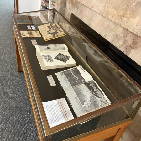 Vitrine with multiple artists’ magazines visible, close up of Avalance open to images of an earth art project in process 