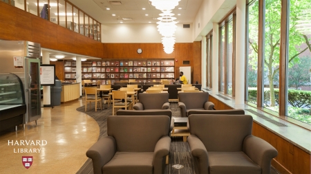 Photograph of a room with couches, desks, and a bookshelf 
