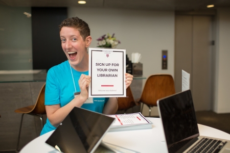 Person holding a sign that says sign up for your own librarian
