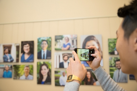 Desmond Ang, Assistant Professor of Public Policy from HKS, snaps a picture of his portrait.