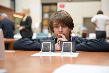 A student takes a closer look at glass slides of the Great Molasses Flood. 