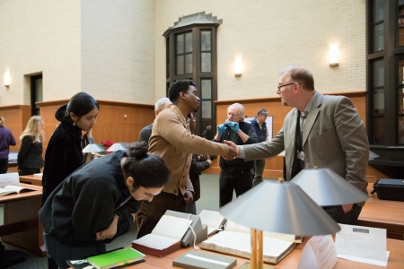 Mahnoor Ali, '19, (left) and Ernest Mitchell (center) page through Satayana's notebooks with librarian Eric Johnson-DeBaufre.
