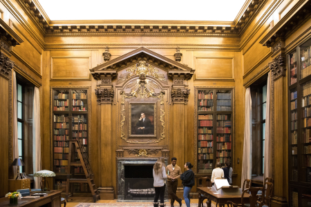 3 people stand in the Memorial Room of Widener Library