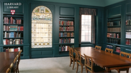 Photograph of a room with 2 bookshelfs filed with books and a table 