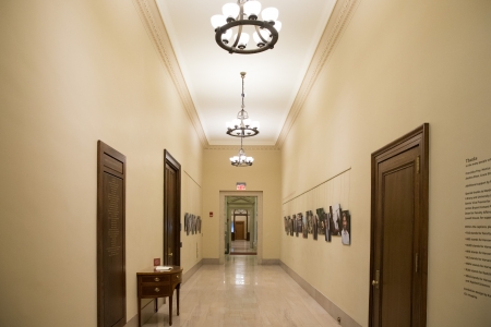 A hallway with portraits hanging on the wall.