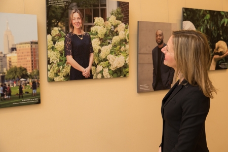 A woman looks at a photo of herself hanging on the wall as part of a photo exhibit.