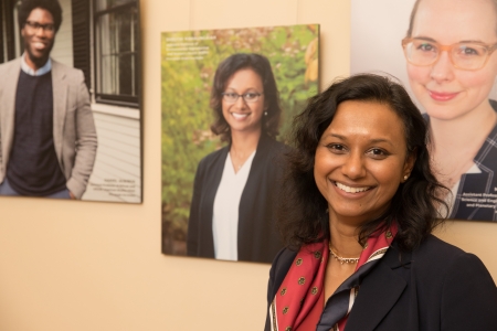 A woman stands in front of her photo portrait, part of a portrait exhibit.