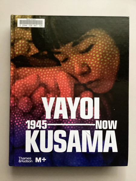 Book cover featuring a photo of Kusama in her twenties, with polka dots on her face, with the title Yayoi Kusama: 1945 – NOW